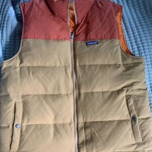 Patagonia Men's Reversible Bivy Down Vest in a tan and rust orange colorway.